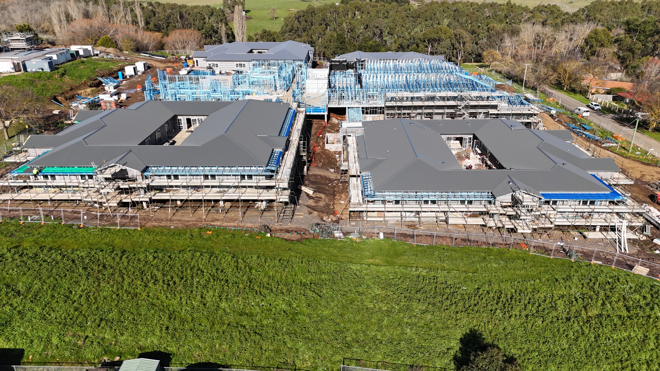 Angled aerial view showing completed roofs and steel framing at the Embracia Aged Care Kyneton construction site.