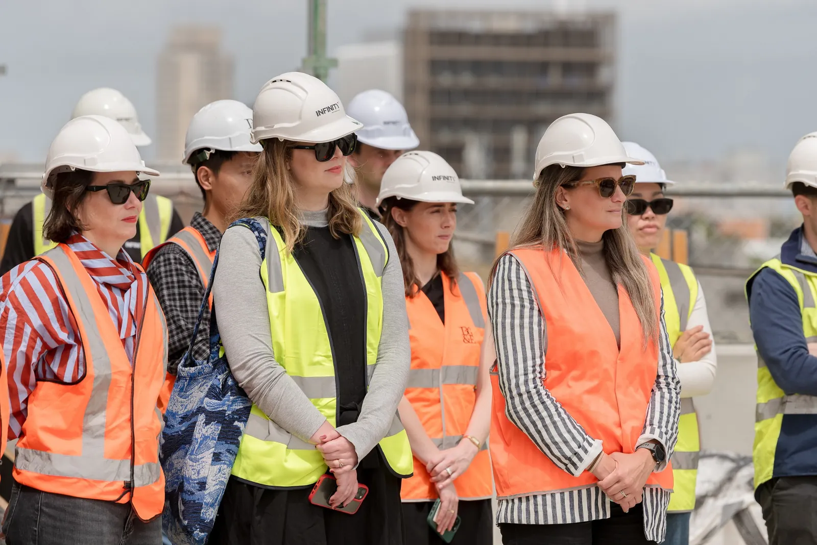 Construction project attendees in hard hats and high-visibility clothing at the event